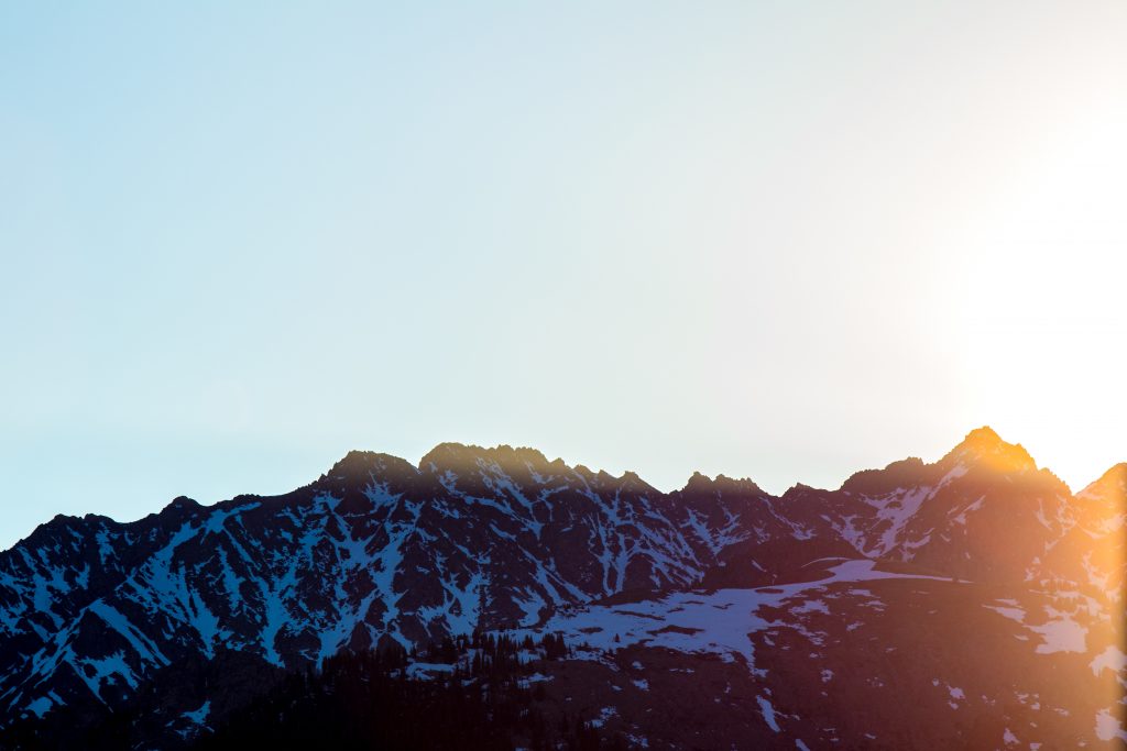 Snow capped mountains and a setting sun