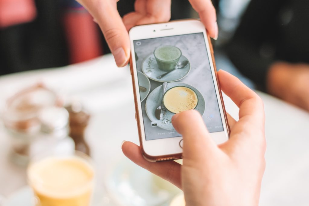 Person taking a photo of coffee for social media